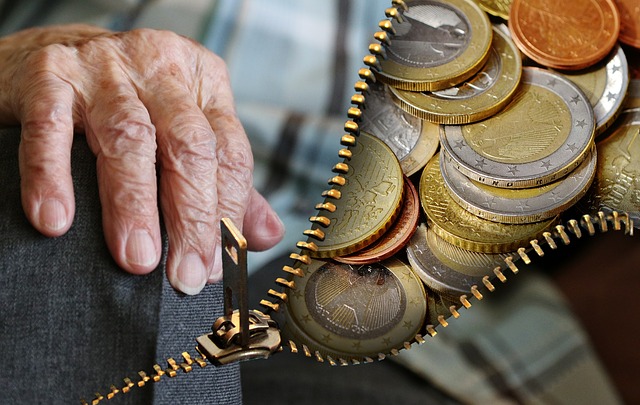 Image with an old persons hand, the image is split with a zip and behind it is coins and money.